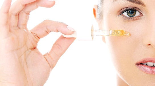 Woman applying Vitamin C serum to her face – skincare routine guide